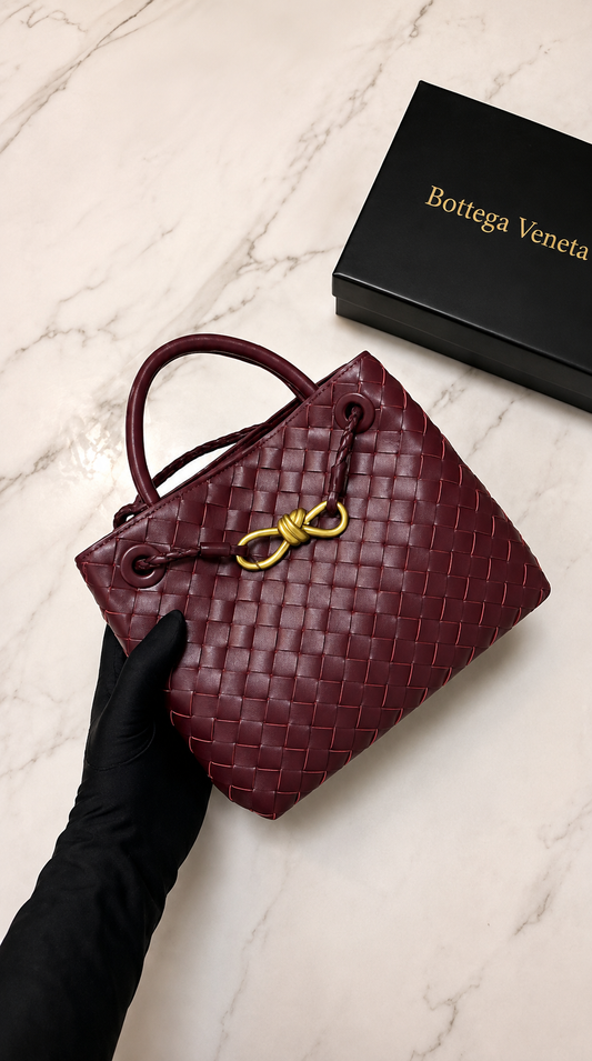 Bottega Veneta Andiamo Small in Barolo leather, featuring a distinctive woven design and gold-tone knot detail.